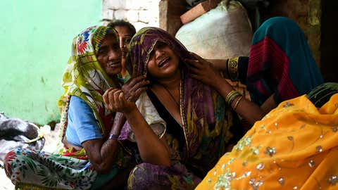 Relatives console Praveena Kumari (center), 22, the wife of 24-year-old Sunil Kumar who died after getting crushed under the debris of a ceiling that fell in heavy storm winds in Kheragarh on the outskirts of Agra on May 4, 2018. (Chandan Khanna/AFP/Getty Images)