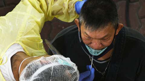A healthcare worker collects swab samples for COVID-19 testing from a worker. (Xinhua/IANS)