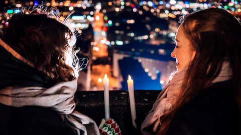 Two people look at city lights while observing Earth Hour with candles in Helsinki, Finland. (©WWF/Linda Manner)