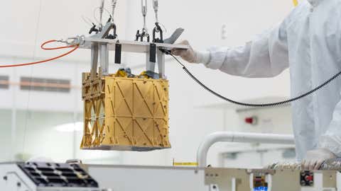 Technicians in the clean room are carefully lowering the Mars Oxygen In-Situ Resource Utilization Experiment (MOXIE) instrument into the belly of the Perseverance rover (NASA/JPL-Caltech)