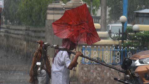 Man crosses a road in heavy rains (SUBHRAJIT CHANDRA/ BCCL - KOLKATA)