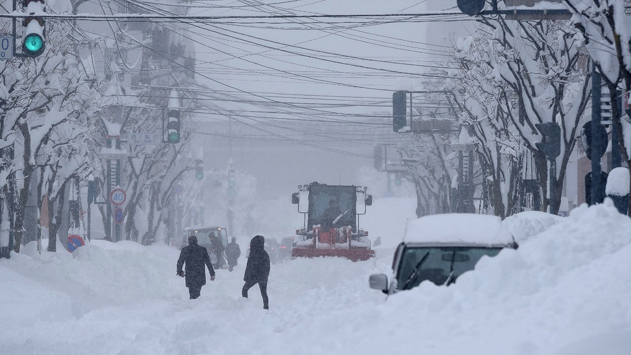 Heavy machinery is used to clear a road as snow falls across northern Japan, in the city of Obihiro, Hokkaido prefecture on February 4, 2025.