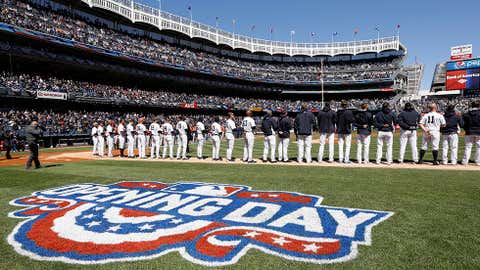 New York Yankees players stand on the firs baseline during the national anthem before an opening day baseball game against the Houston Astros in New York, Tuesday, April 5, 2016.