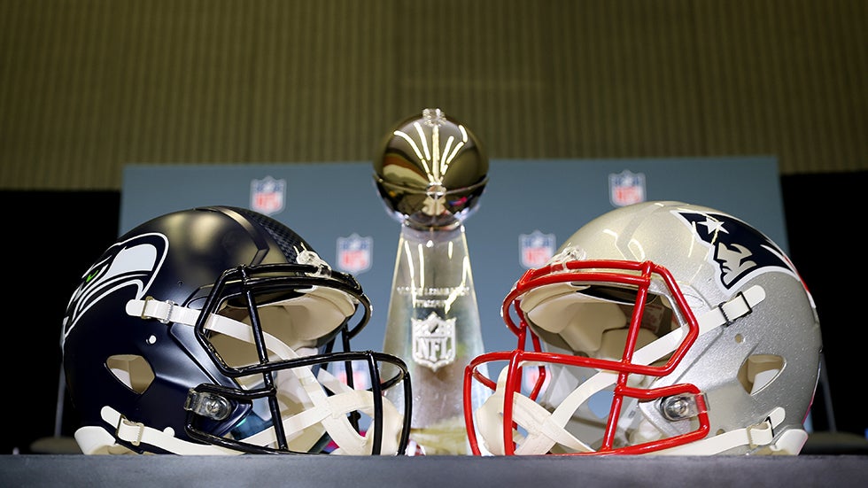 SAN JOSE, CALIFORNIA - FEBRUARY 02: The Vince Lombardi Trophy is framed by the Seattle Seahawks and New England Patriots helmets during Super Bowl LX Opening Night at San Jose McEnery Convention Center on February 02, 2026 in San Jose, California. (Photo by Chris Graythen/Getty Images)
