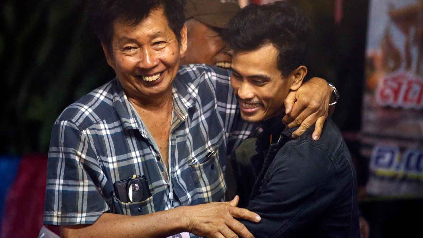 FILE - In this Monday, July 2, 2018, file photo, family members hug after hearing the news that the missing 12 boys and their soccer coach have been found in the flooded cave in Mae Sai, Chiang Rai province, northern Thailand. For the boys and their coach, we have only a hint of what it might have been like. But for the rest of us, watching from afar as the world&acirc;&euro;&trade;s journalists beamed us live shots and the unknowable became known drip by captivating drip, we knew only one thing: It was hard to look away. (AP Photo/Sakchai Lalit, File) 