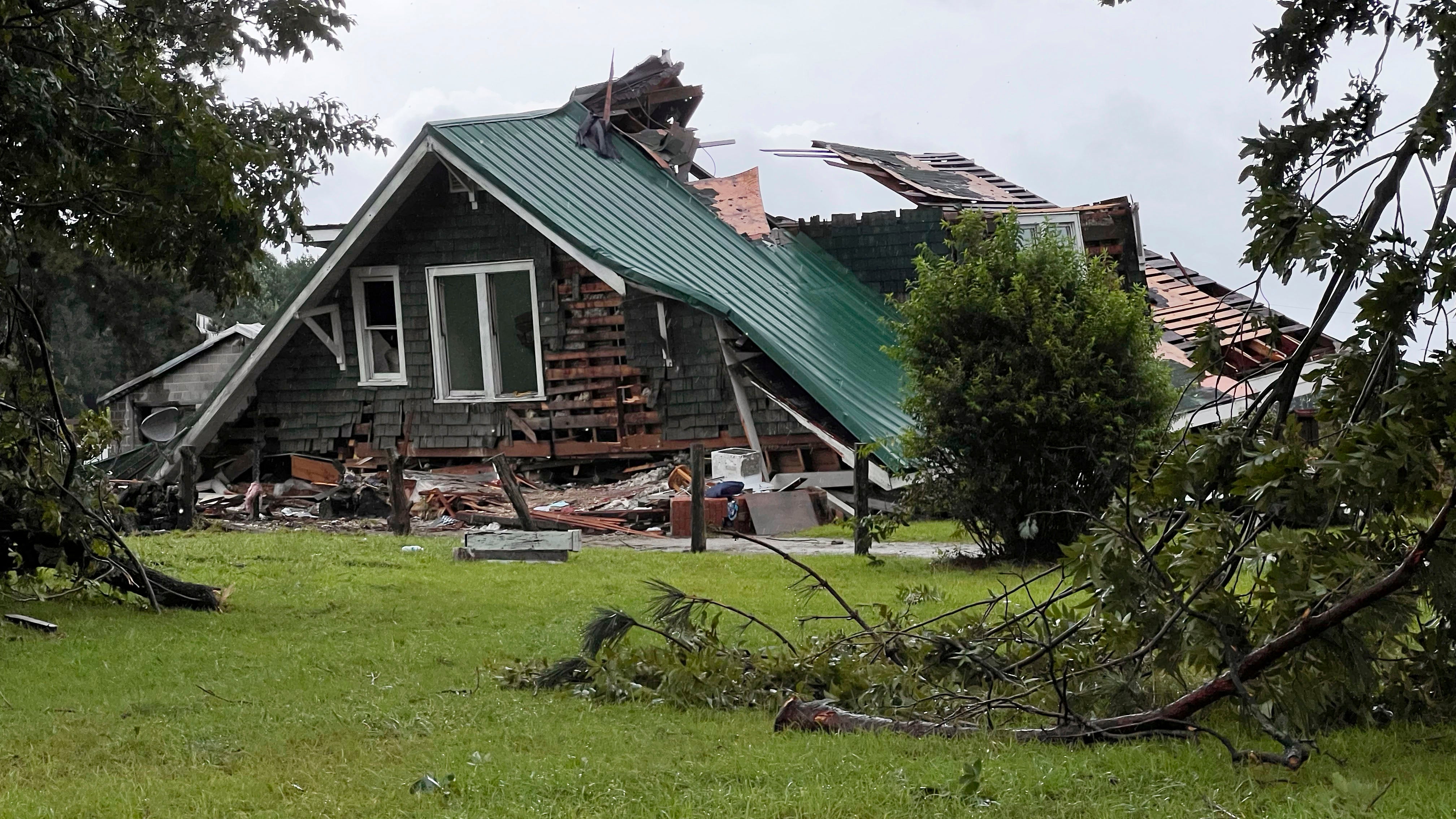 A roof collapsed on a house when a tornado hit near Lucama, N.C. as bands from Tropical Storm Debby moved through early Thursday, Aug. 8, 2024.  (Travis Long/The News & Observer via AP)