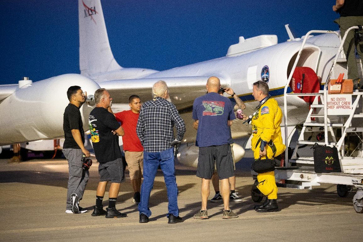Members of NASA and research team discuss flight operations beside NASA's high-altitude ER-2 aircraft before an INSPYRE mission. 