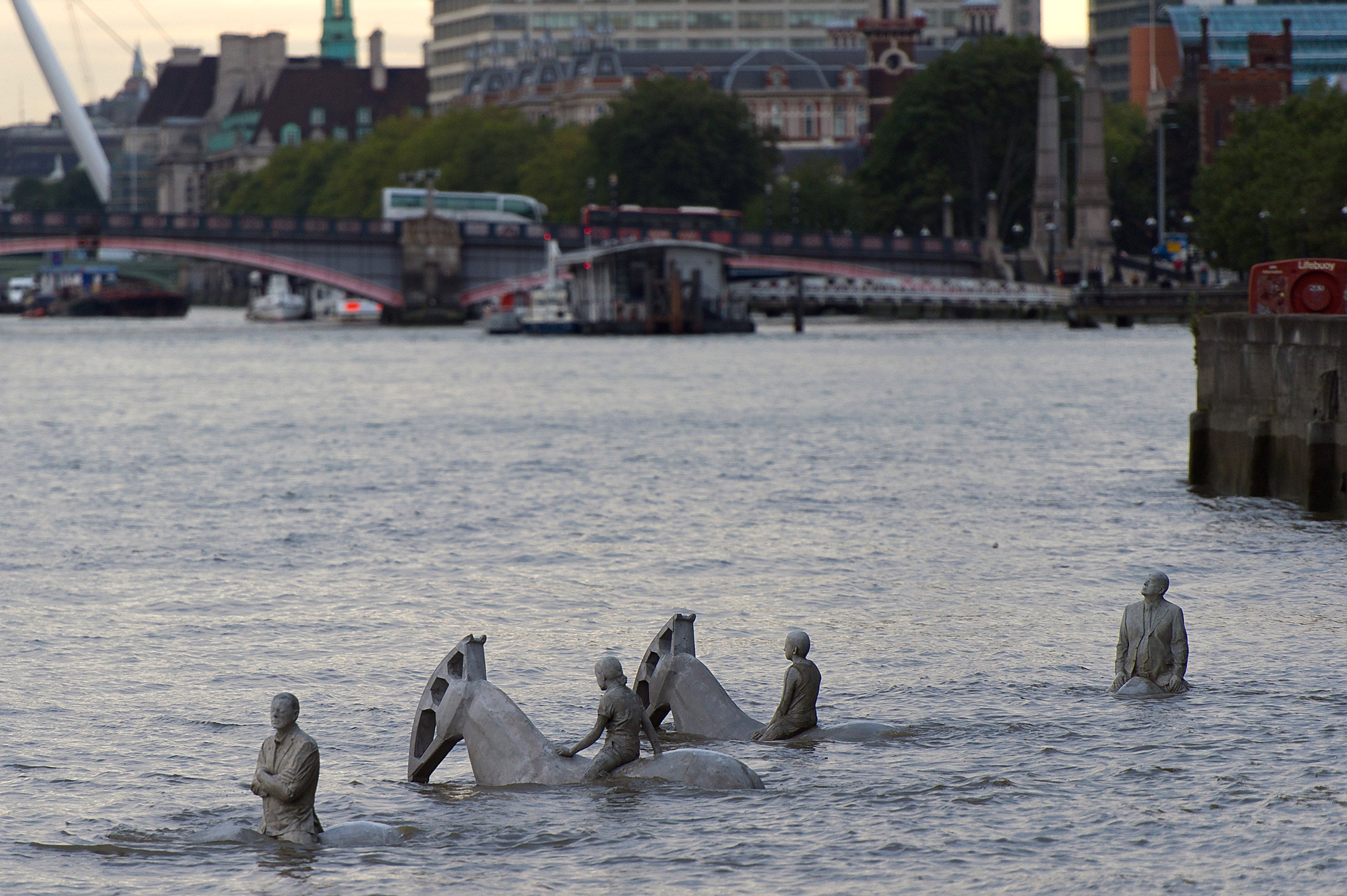 Jason deCaires Taylor's "The Rising Tide" sculptures stand partially submerged in the River Thames in London.