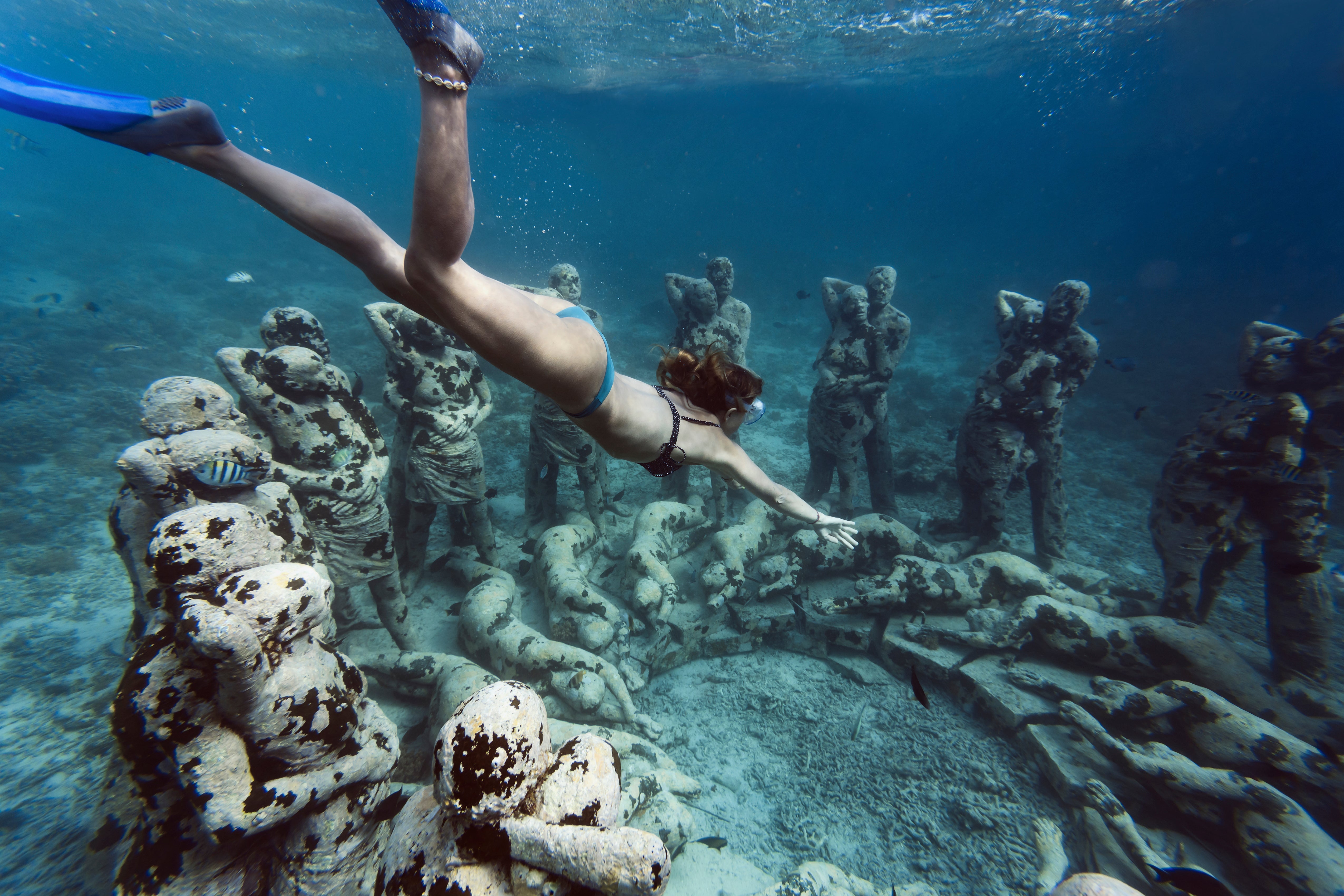 A snorkeler swims above Nest, Jason deCaires Taylor's underwater sculpture installation near Bali, Indonesia.