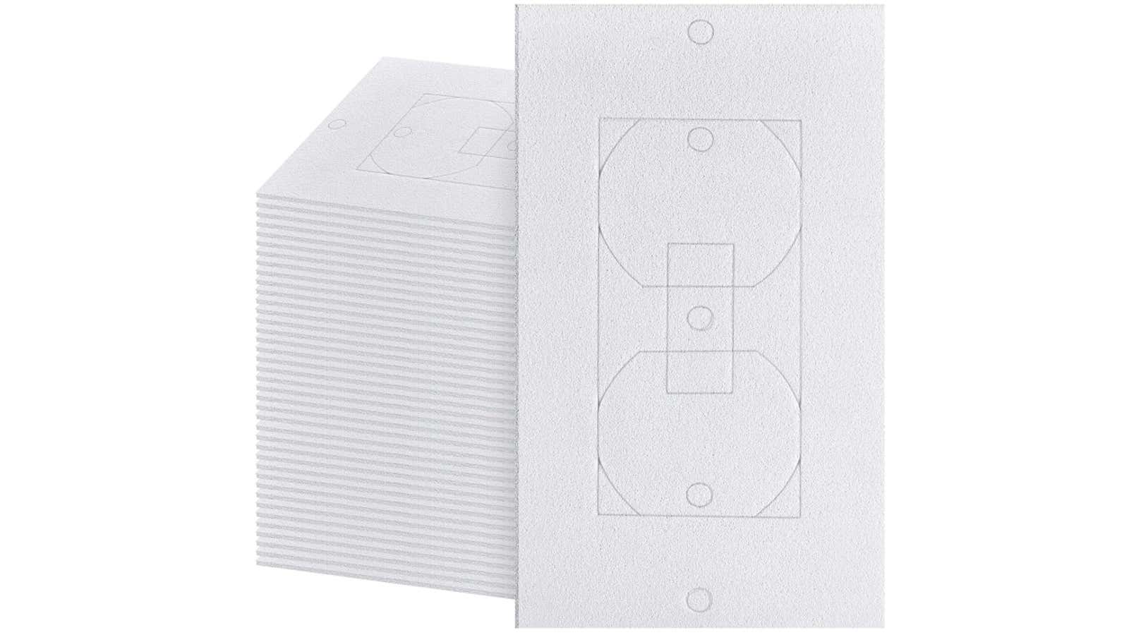 Stack of white textured foam electrical outlet cover templates with outlet outline shape