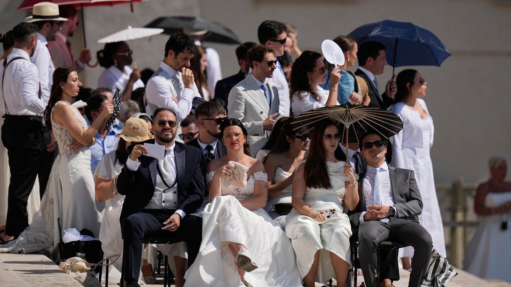 Faithful shelter for the hot sun as they wait for Pope Leo's XIV weekly general audience in St. Peter's Square at The Vatican, Wednesday, June 24, 2026. 