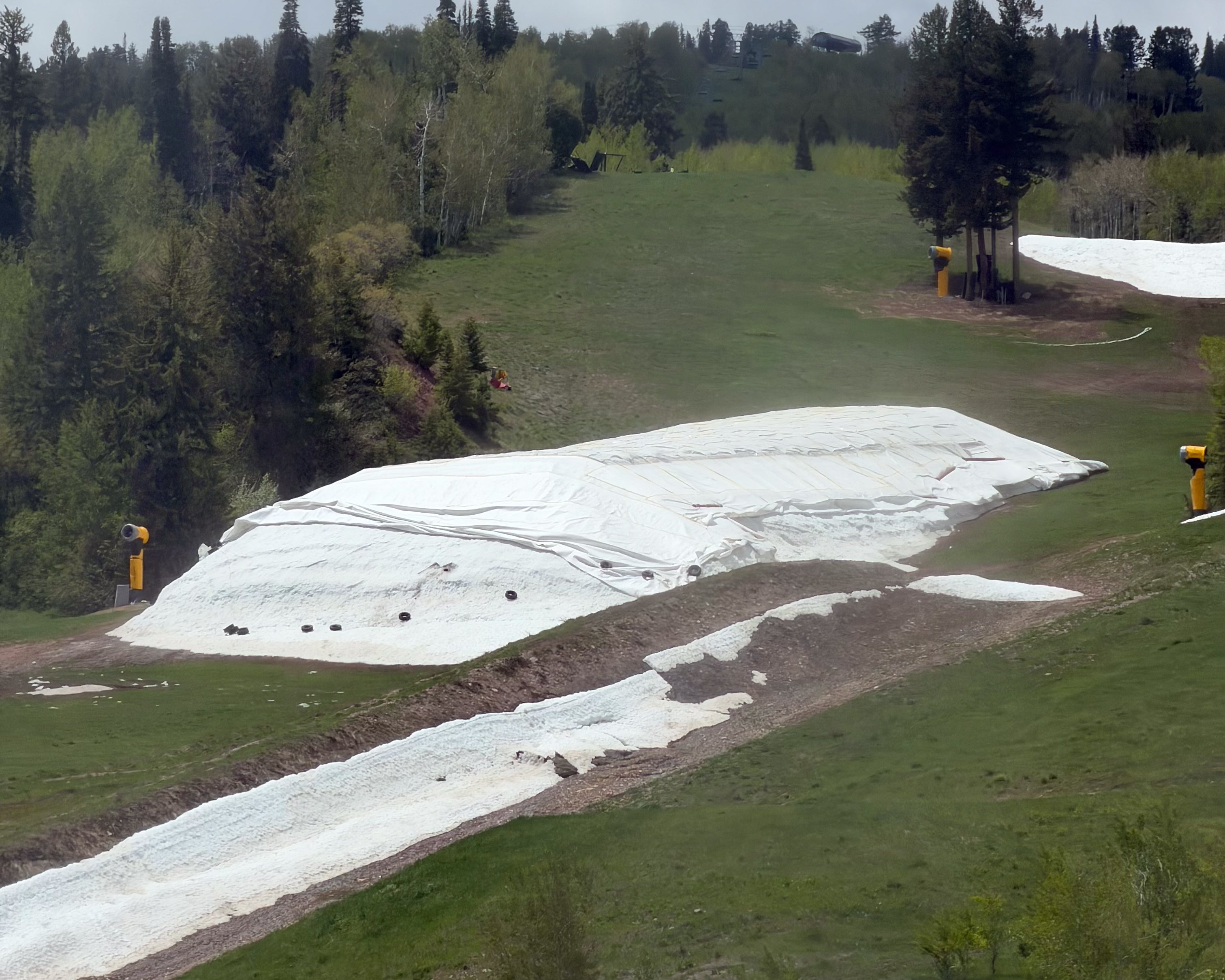 Insulating blankets from Finnish company Snow Secure cover a pile of leftover snow, shielding it from summer heat so it can be used for early-season skiing.