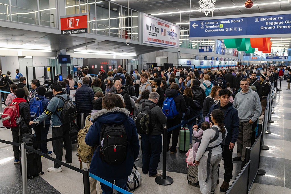 Travelers wait in line at a security checkpoint in Terminal 3 at O'Hare International airport on November 30, 2025 in Chicago, Illinois. 