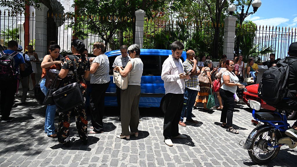 Evacuated workers check their cell phones after a tremor caused by a 6.5-magnitude earthquake in Havana, on June 8, 2026. 