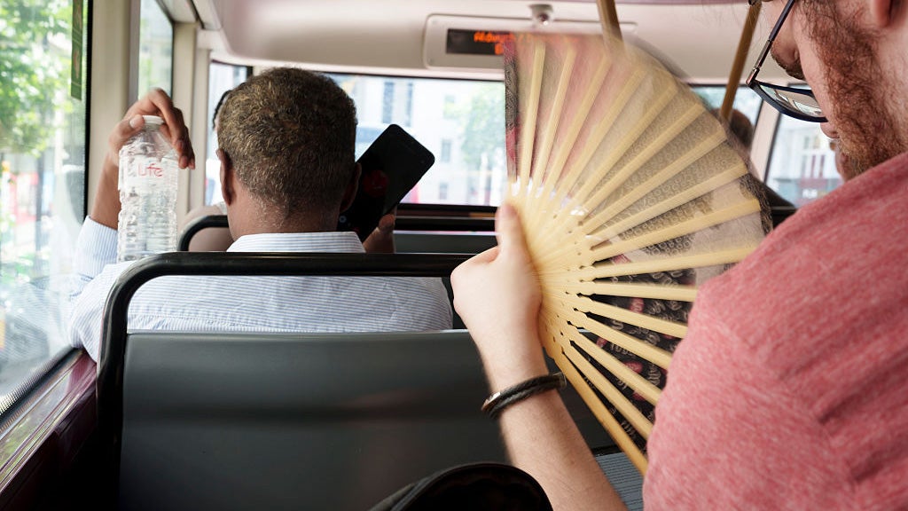 a bus passenger fans themself.