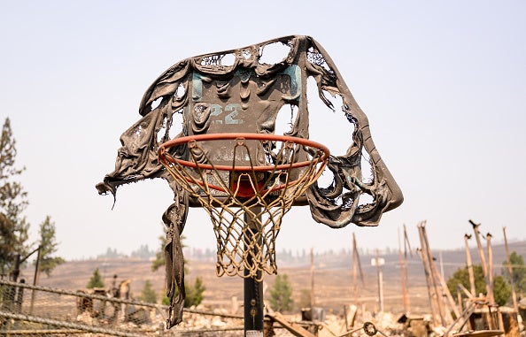 A melted basketball backboard and hoop is seen among the burned remains of Riverside Real Life Church after it burned down during the Old Trails fire in Spokane, Washington on August 4, 2026. 