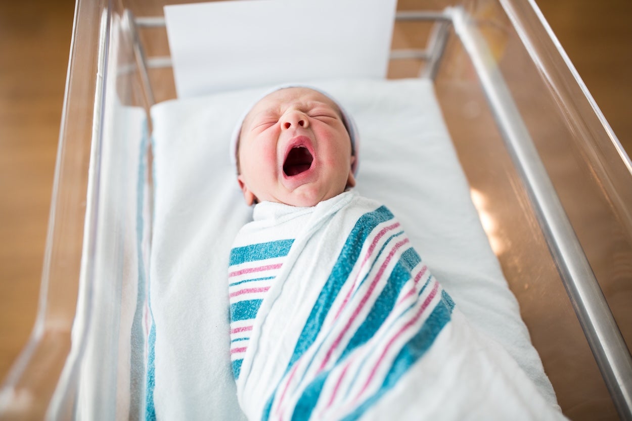 This image shows a one day old newborn in a hospital room.