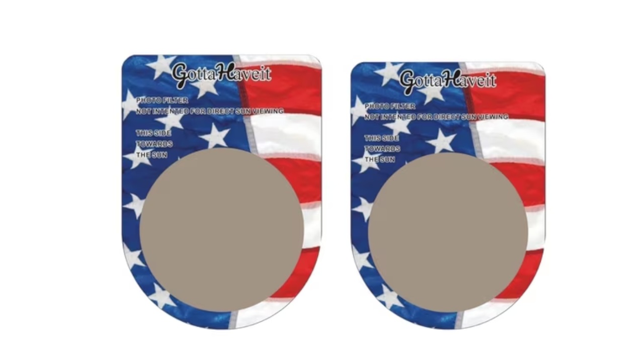 Two American flag-patterned solar eclipse viewer glasses labeled "GottaHaveit" with photo filter safety instructions