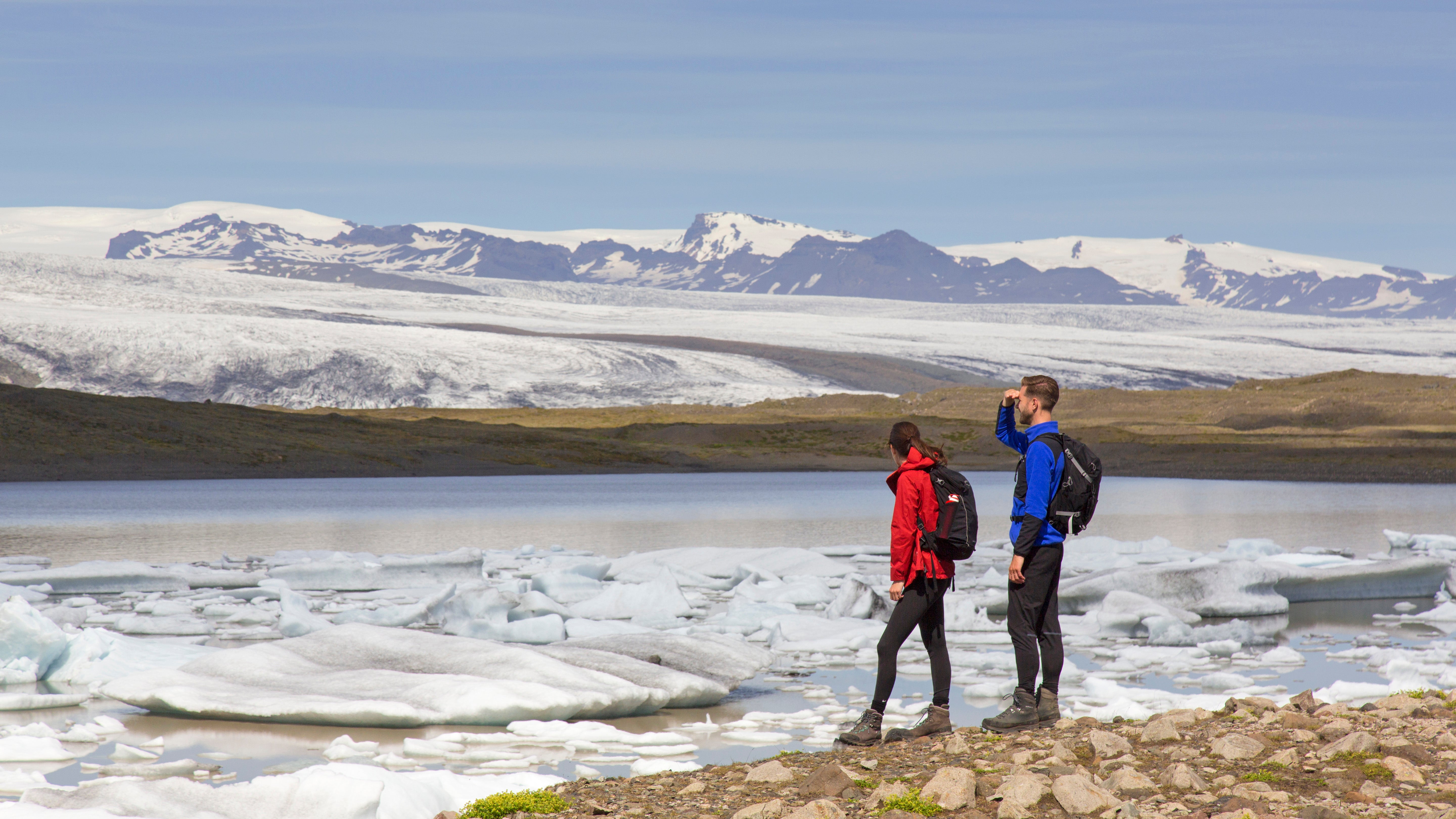 Tourists looking over the glacier lake Fjalls&aacute;rl&oacute;n and Icelandic glacier Fjallsj&ouml;kull, part of Vatnaj&ouml;kull in summer in Iceland. 