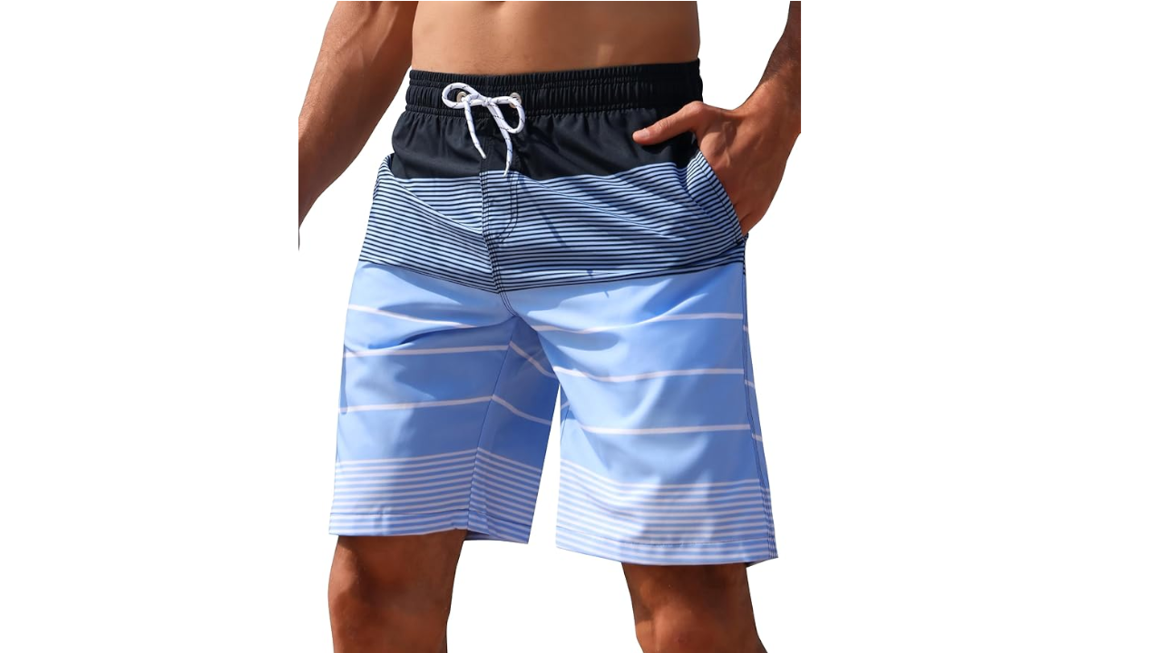 Man wearing blue and navy swim trunks with geometric striped pattern and white drawstring, hands in pockets