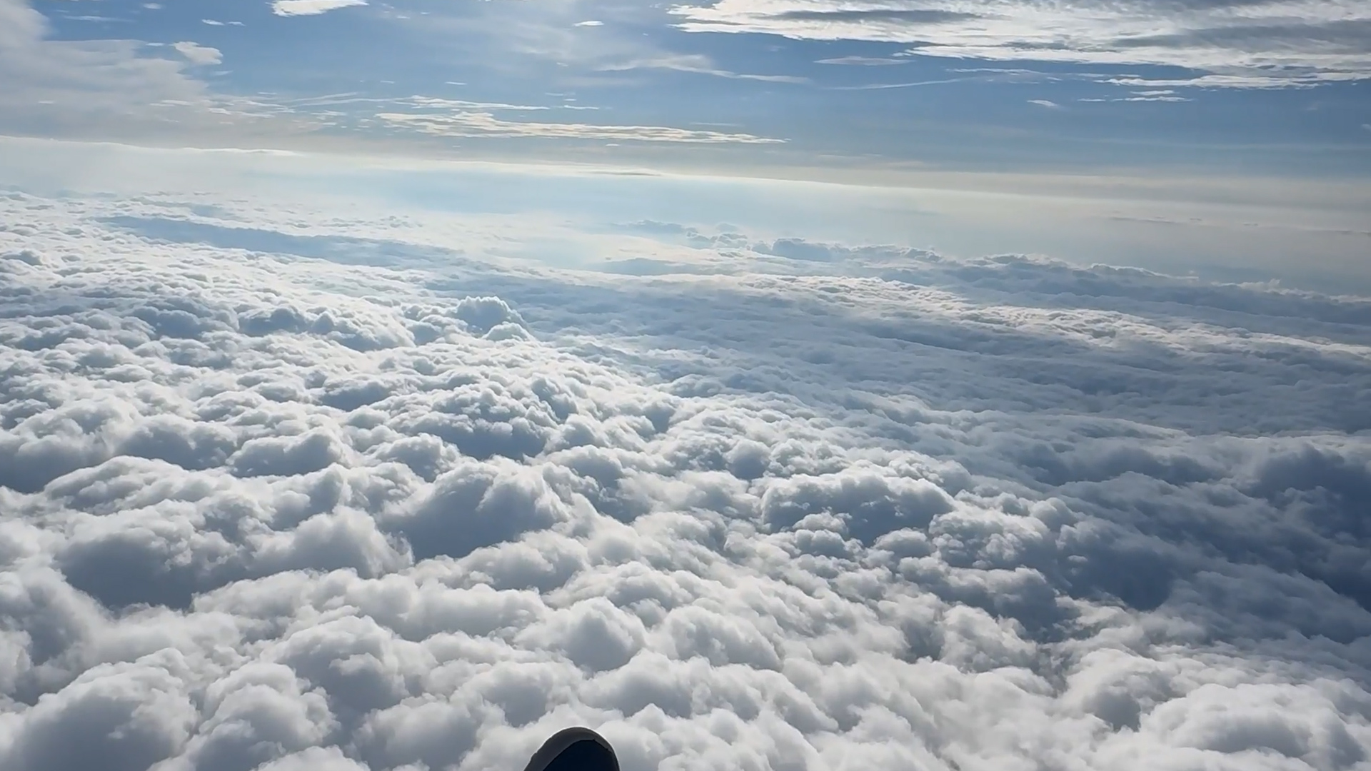 Paramotor pilot soars above sea of clouds