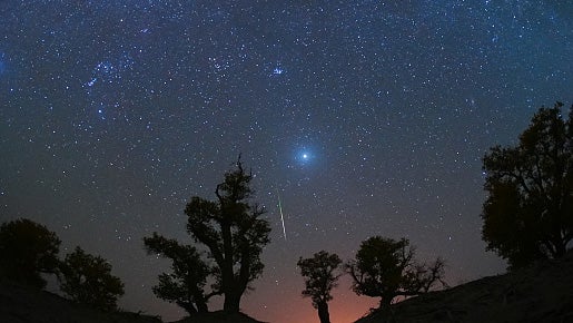 A meteor streaks across the sky over a desert in China during the Orionid meteor shower on Oct. 22, 2023.