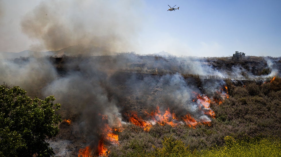 The Sandy Fire burns vegetation on Monday, May 18, 2026, in Simi Valley, Calif. (AP Photo/Ethan Swope)