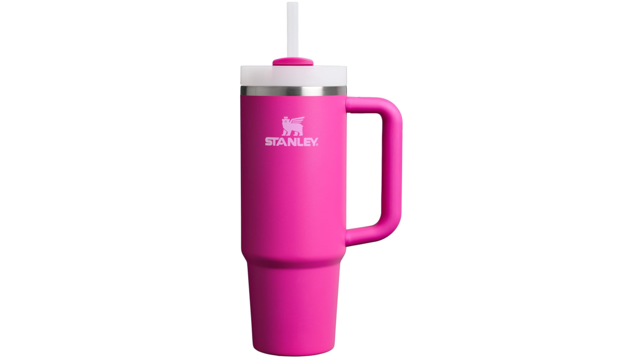 Pink Stanley insulated travel mug with white logo, stainless steel rim, handle, and clear straw lid
