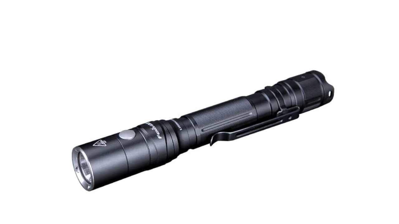 Black tactical flashlight with clip on a white background