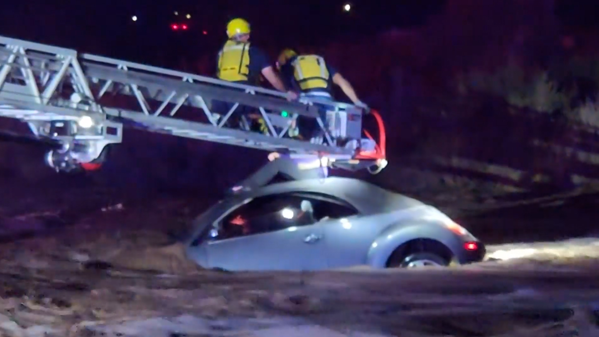 Firefighters use ladder to rescue driver from roof of car