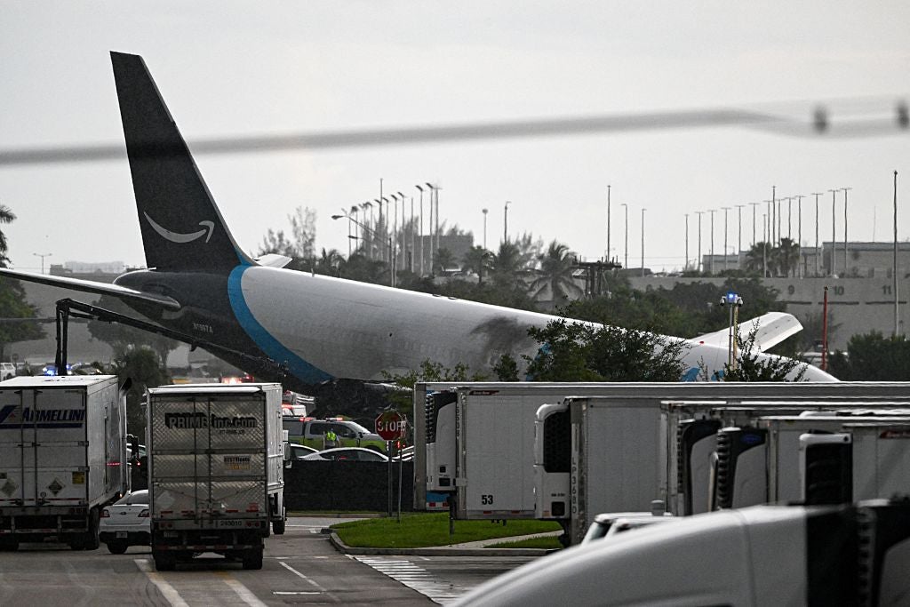 The tail section of a cargo plane is seen at Miami International Airport after it overran the runway at Miami International Airport in Miami, Florida, on September 6, 2026. An Amazon cargo plane overshot a runway as it landed in Miami, crashing into vehicles and catching fire, officials said. There was no immediate word on casualties in the incident reported by the Federal Aviation Administration (FAA) and Miami International Airport. Video showed smoke billowing from a Boeing 767 operating for Amazon Prime Air. 