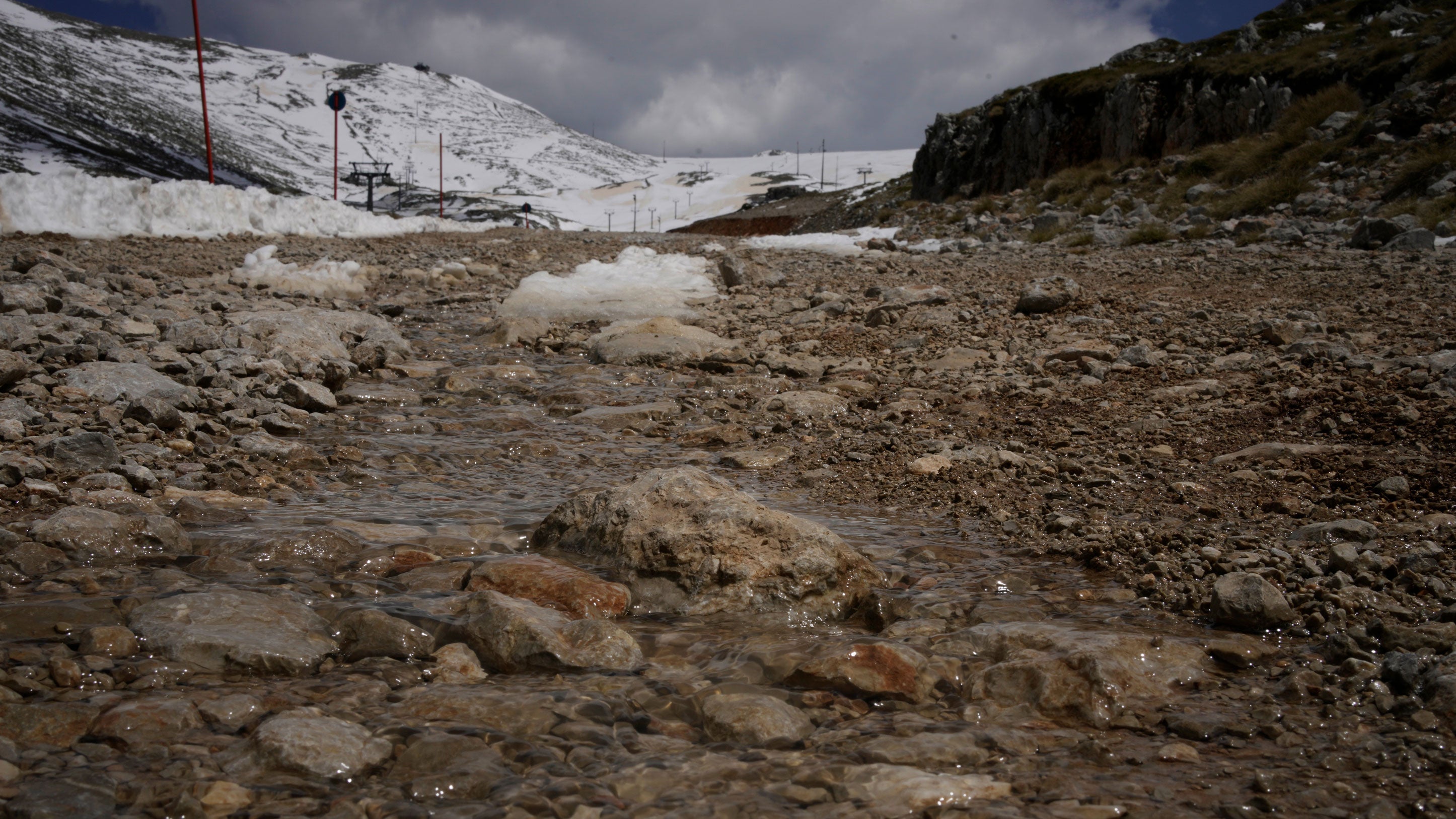 Water from melting snow flows down the slopes of Mount Parnassos at the Kelaria ski center in central Greece, on May 5, 2026.