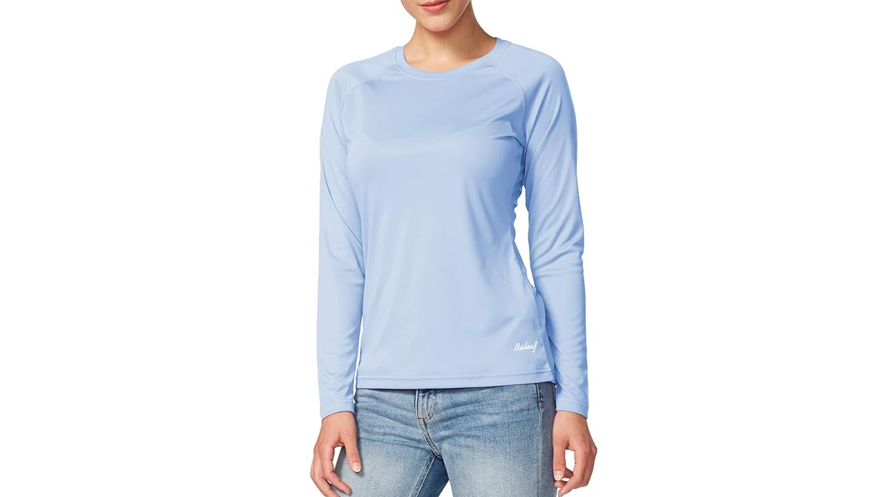 Woman wearing light blue long-sleeved shirt and jeans against white background