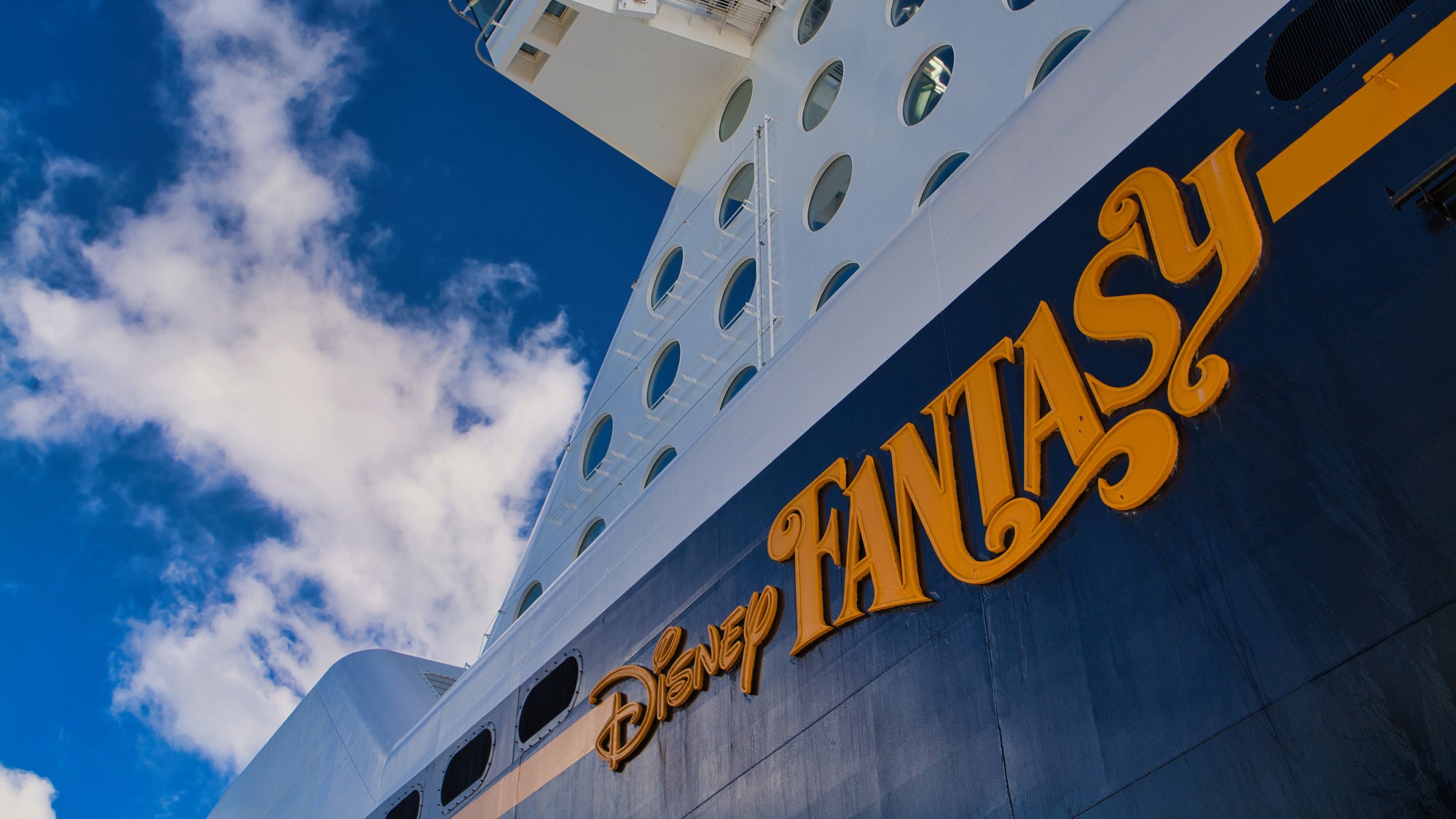  Passengers look out as the Disney cruise ship Magic heads to sea for a cruise. The Disney Mickey logo is on the smoke stack.