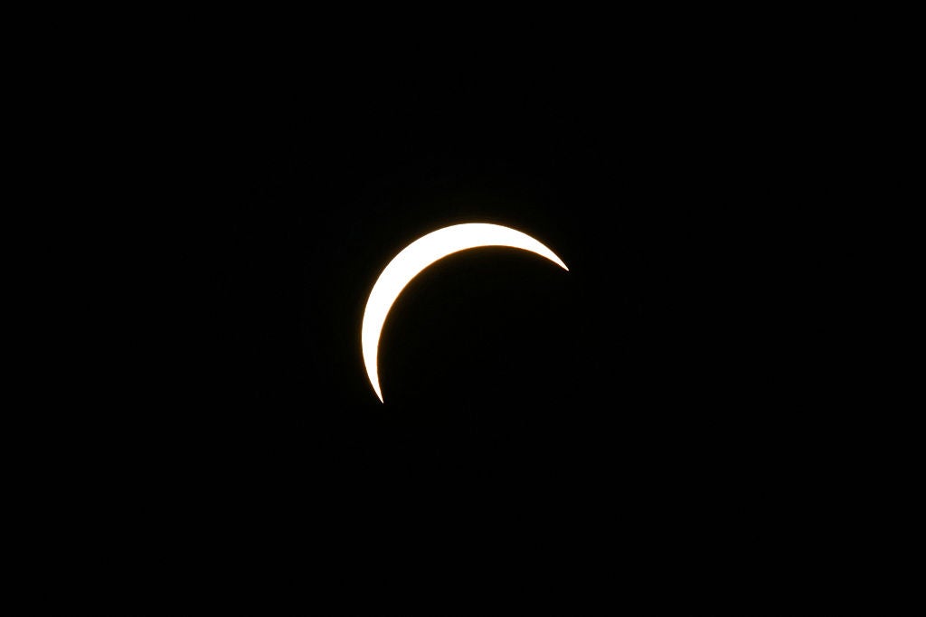 Crescent shape of the sun visible during a partial solar eclipse against a black sky