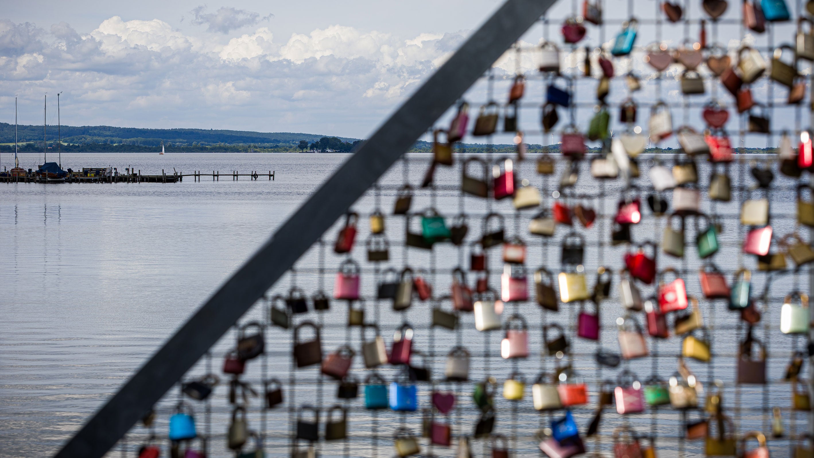 Love locks hanging from a lattice on the Steinhuder Meer in the Hanover region in cloudy weather.