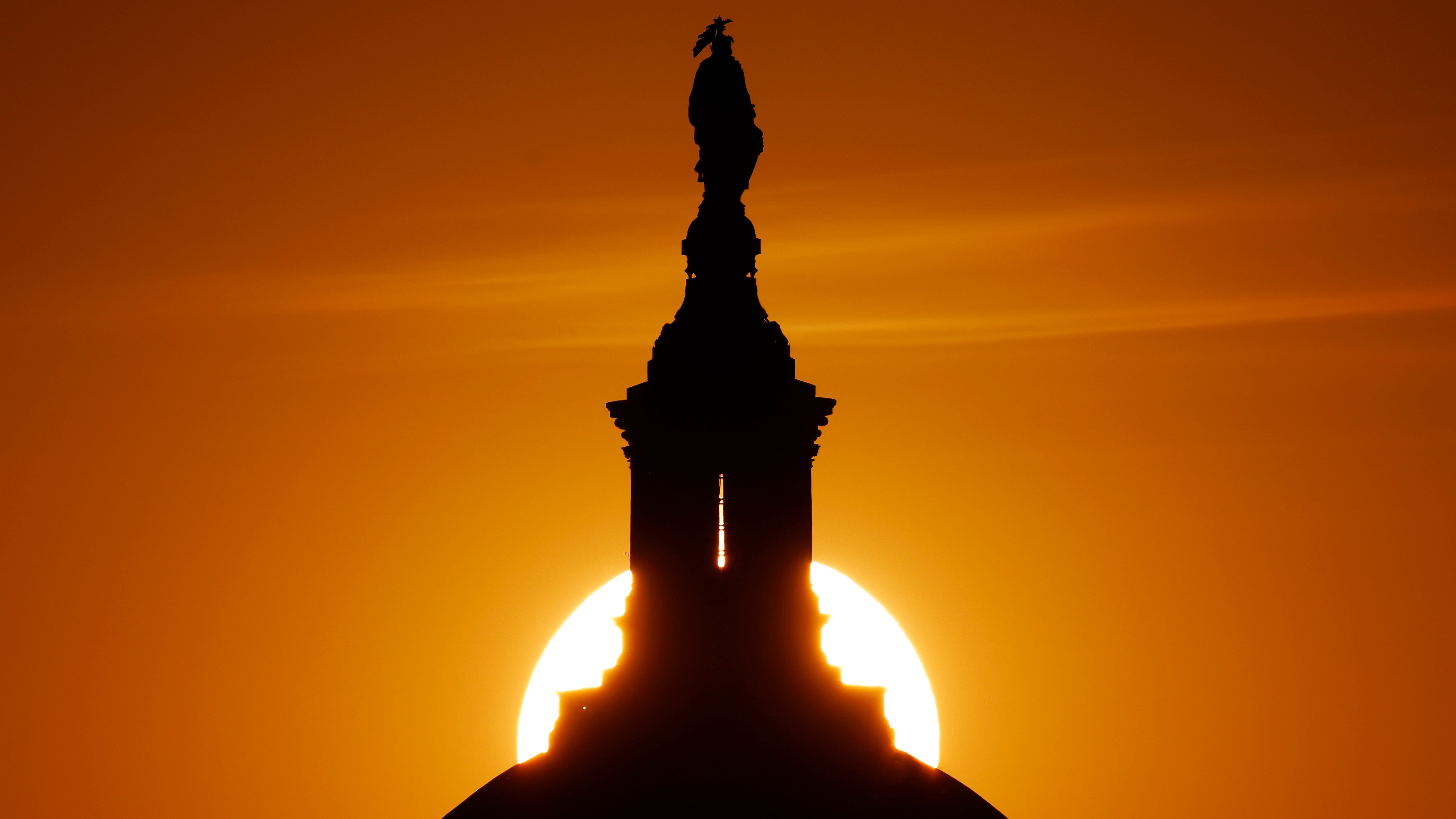 The sun sets behind the Statue of Freedom on top of the U.S. Capitol Building during a spring heat wave on June 5, 2026 in Washington, DC. 