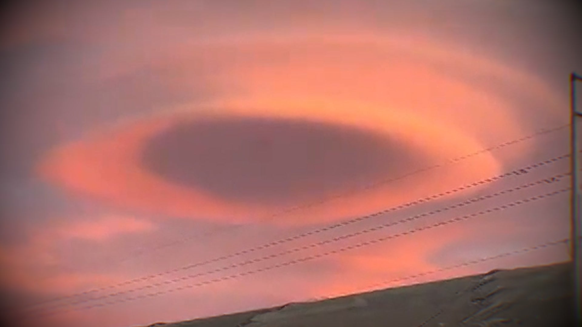 Stunning lenticular clouds glow pink and orange at sunset