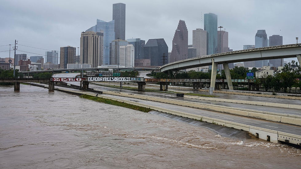 Flood waters almost reaching a freeway with the skyline of Houston in the background
