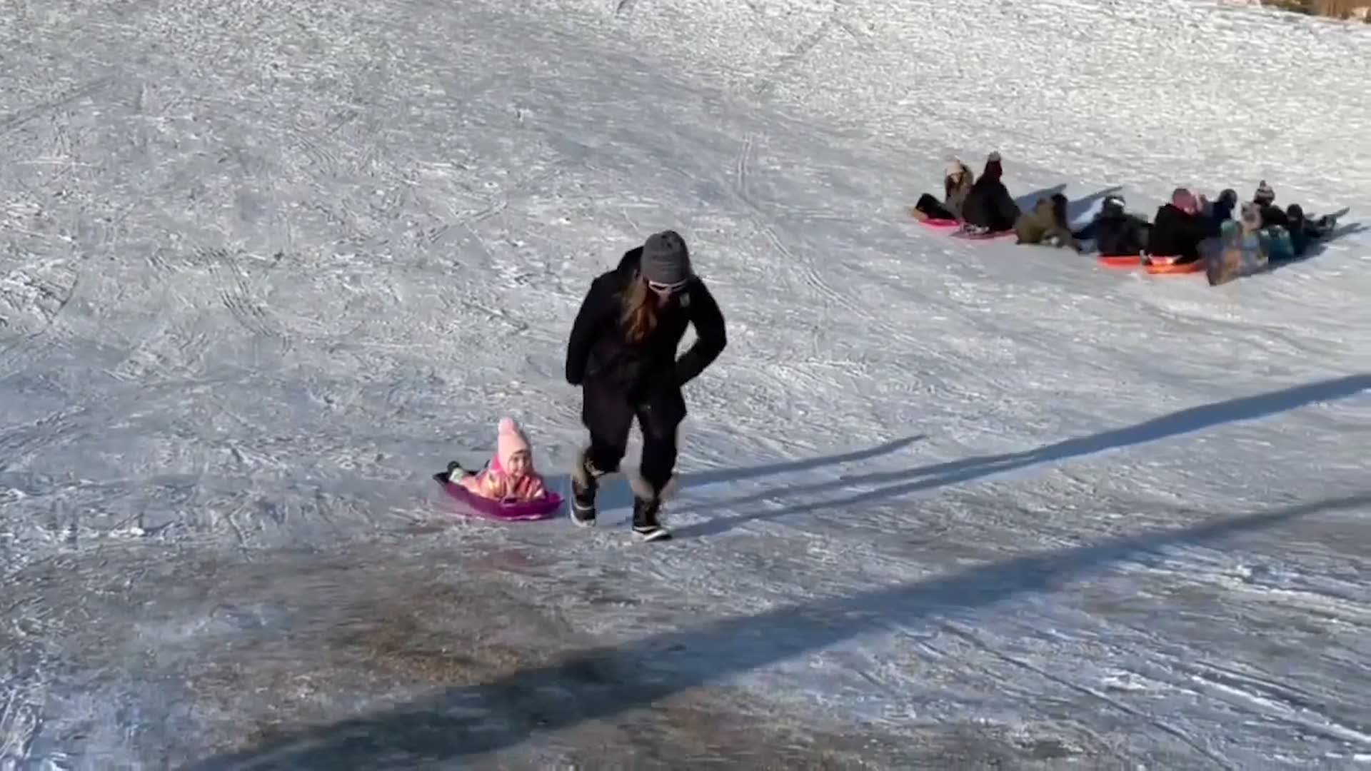 Mom Struggles to Pull Sled Up Icy Hill