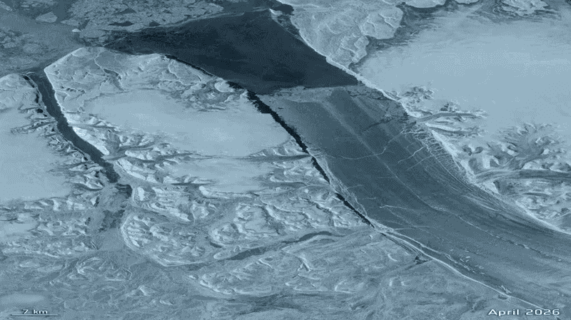 Satellite image of a frozen river or fjord with ice cracks and snow-covered terrain, dated April 2026 with a 7 km scale bar