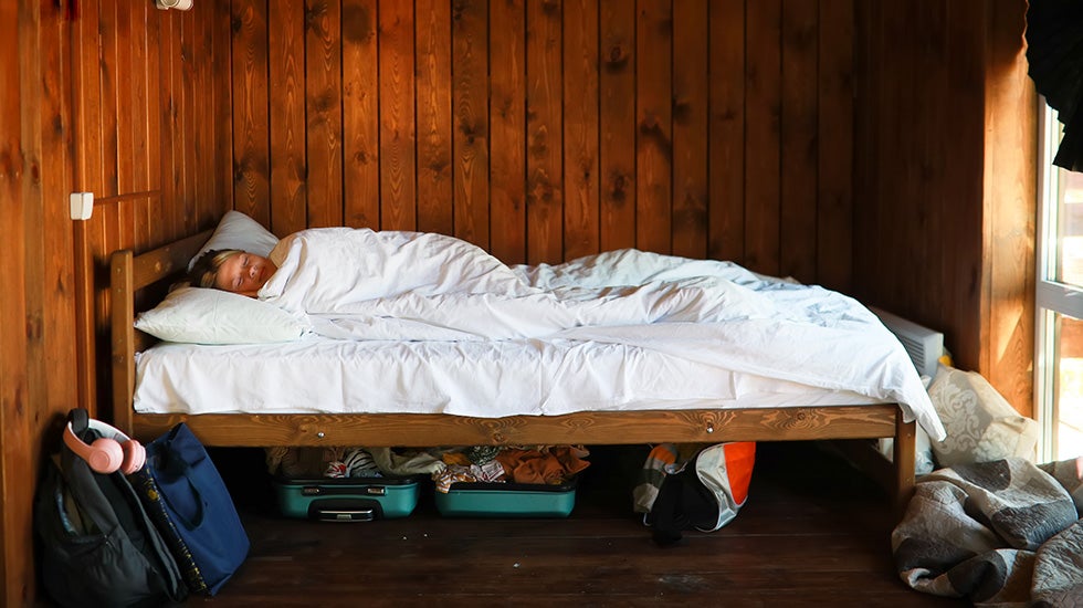 Teenager wrapped in blankets on a bed