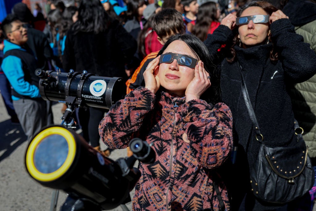 A woman viewing a solar eclipse while wearing eclipse glasses