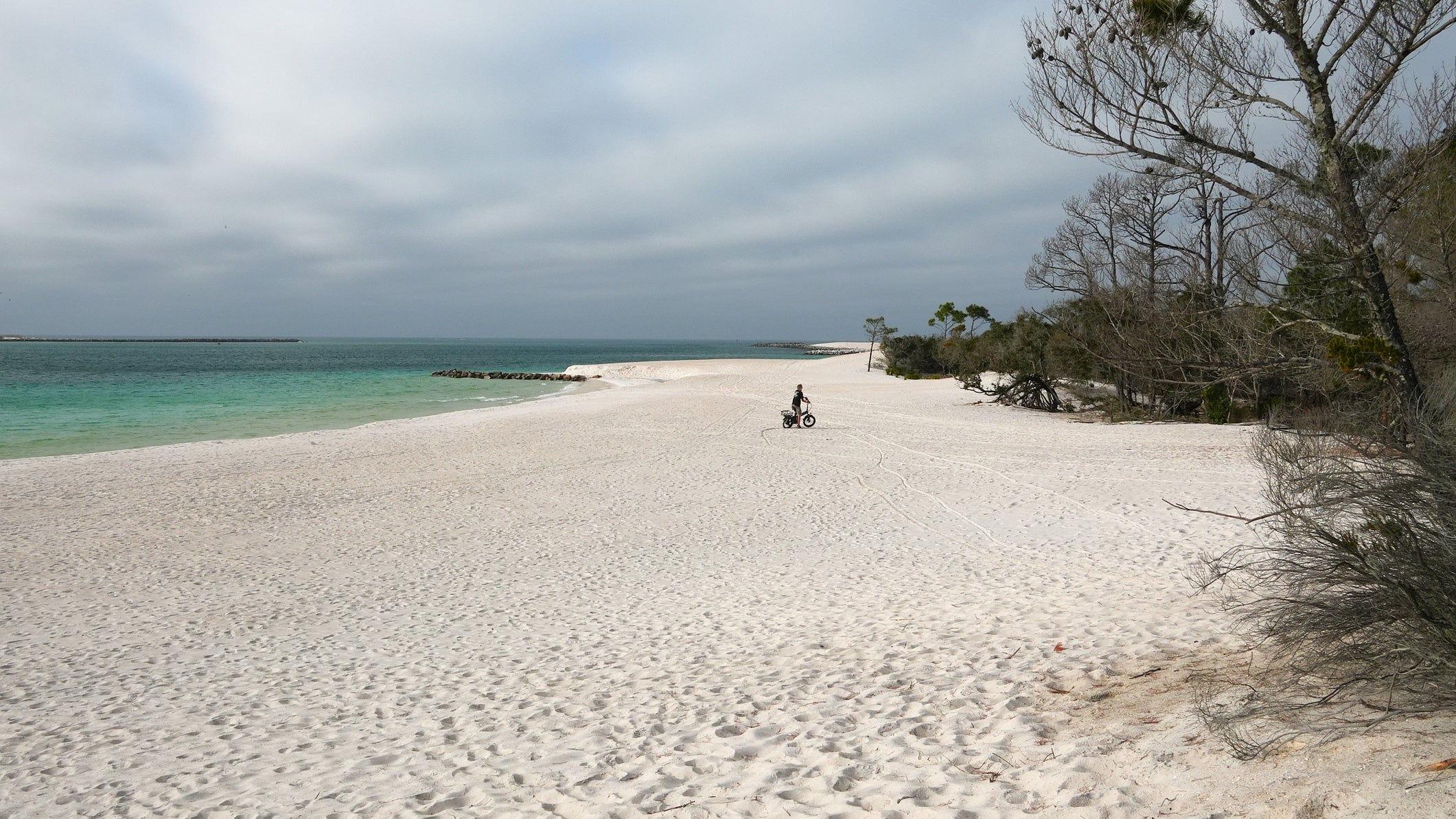 A bike rider on the pristine beach of St. Andrews State Park in Panama City, Florida.