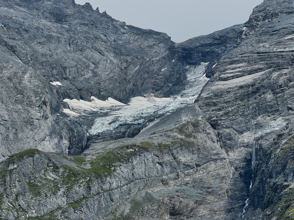 Rugged mountain slopes with a glacier flowing down between rocky cliffs