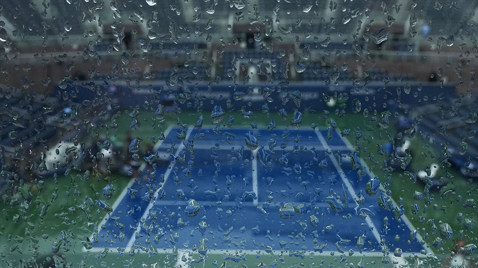 Raindrops cover a window overlook a tennis court