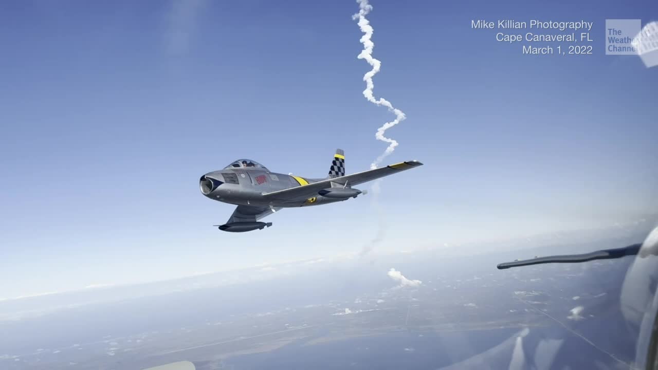 Vintage Fighter Jet Soars as Rocket Launches