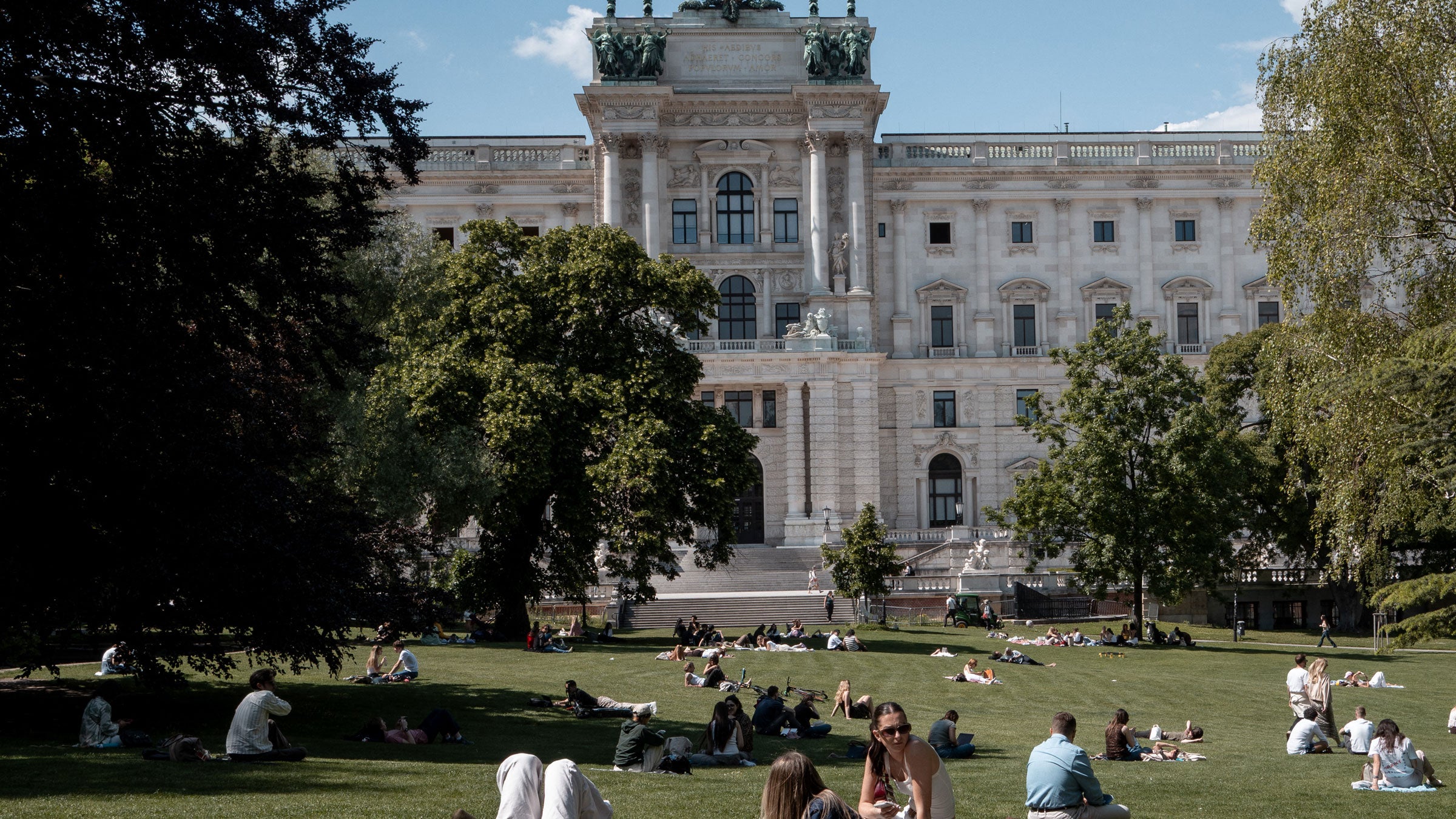 People hang out in the sun at Burg garden behind the Imperial Hofburg palace in Vienna, Austria, on May 19, 2026.