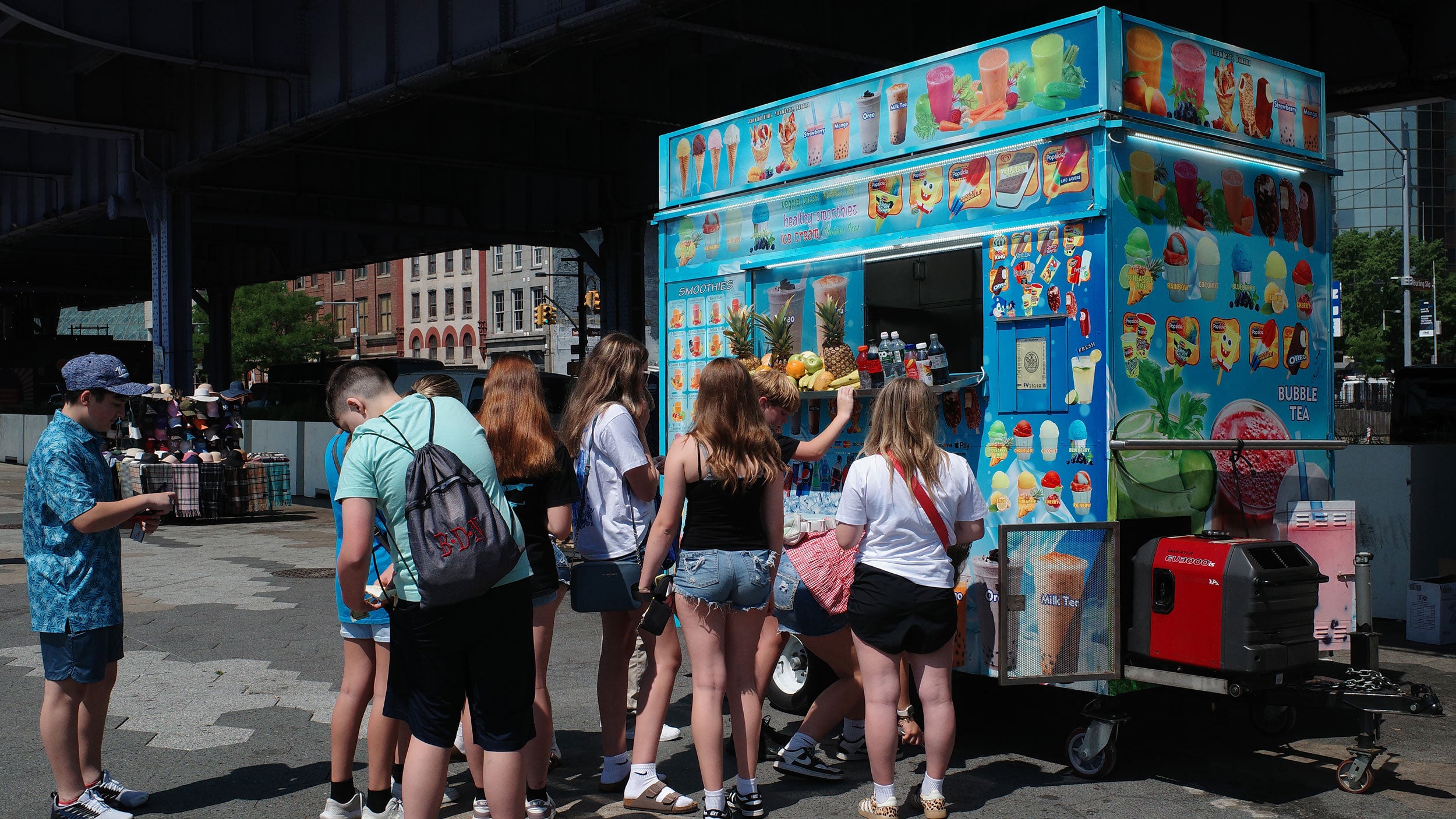 People wait to purchase fruit smoothies amid a heat advisory from a street vendor on South Street on May 19, 2026, in New York City. The National Weather Service issued a heat advisory for NYC and New Jersey, as temperatures are expected to reach into the 90s.