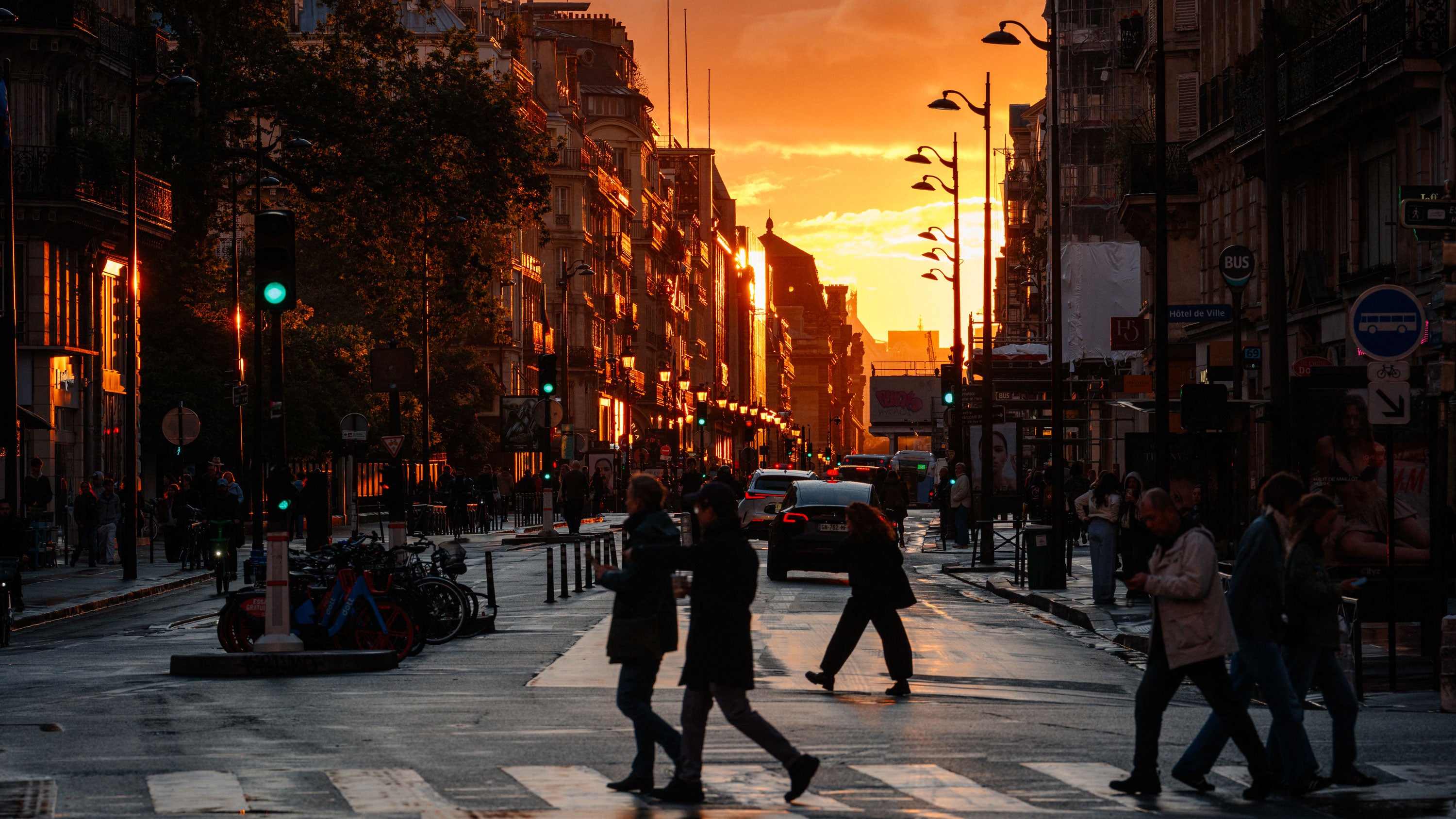 Pedestrians cross rue de Rivoli at sunset in Paris on May 14, 2026.